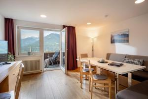 a living room with a table and a room with a view at Ferienwohnungen Tiroler Alpenhof in Innsbruck