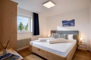 a bedroom with a bed with white sheets and a window at Ferienwohnungen Tiroler Alpenhof in Innsbruck
