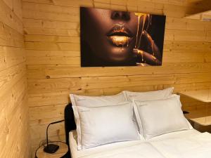 a bedroom with wooden walls and a bed with white pillows at Radovna Chalet with Panoramic View in Mojstrana