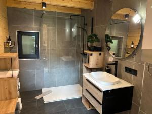 a bathroom with a shower and a sink and a mirror at Radovna Chalet with Panoramic View in Mojstrana
