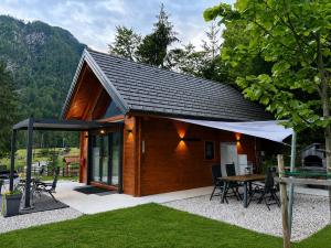 a small wooden cabin with a table and chairs at Radovna Chalet with Panoramic View in Mojstrana