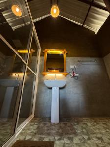 a bathroom with a white sink and a mirror at Saffron Eco Cottage in Ella