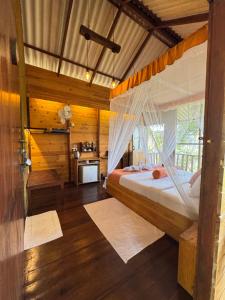 a bedroom with a bed with a mosquito net at Saffron Eco Cottage in Ella