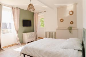 a bedroom with a white bed and a television at L'écrin des quatre puits in Cesny-aux-Vignes +64 photos