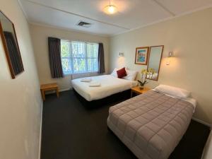 a hotel room with two beds and a window at Kowhai Motel Rotorua in Rotorua +68 photos