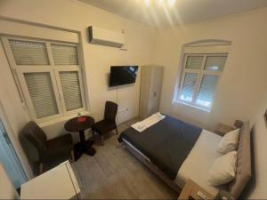 a bedroom with a bed and a chair and a television at Tabacco in Obrenovac