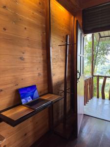 a laptop computer sitting on a wooden wall in a cabin at Saffron Eco Cottage in Ella