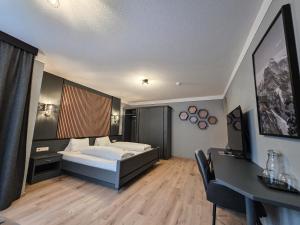 a bedroom with a bed and a desk in a room at Hotel Lärchenhof in Kaunertal