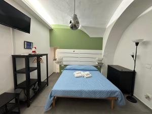a bedroom with a blue bed with towels on it at La Casa di Orlando in Catania