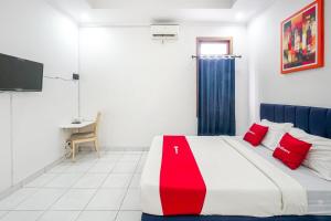 a bedroom with a large bed with red pillows at RedDoorz Plus near Universitas Maranatha Bandung 2 in Bandung