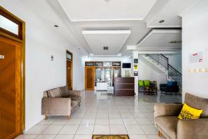 an office lobby with couches and a staircase at RedDoorz Plus near Universitas Maranatha Bandung 2 in Bandung