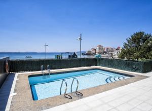 a swimming pool next to the ocean with at Alda Carril in Vilagarcia de Arousa