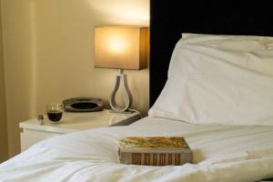a book on a bed with a lamp and a glass of wine at Watervale Retreat in Watervale +36 photos