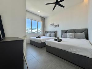 a bedroom with two beds and a ceiling fan at Langkawi Simfoni Beliza Apartment with Sky Pool by Zervin in Kuah