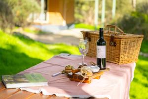 a picnic table with a bottle of wine and a glass at Watervale Retreat in Watervale