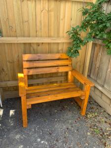 a wooden bench sitting in front of a fence at Seymour Studios in Seymour