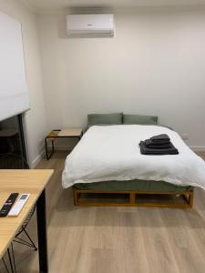 a bedroom with a bed with white sheets and a desk at Seymour Studios in Seymour