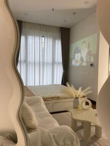 a bedroom with a bed and a table and a window at Bảo Châm Homestay in Gia Lâm Pho