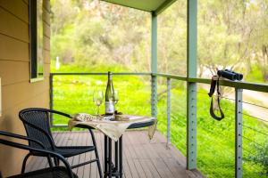 a table with wine glasses and a camera on a porch at Watervale Retreat in Watervale