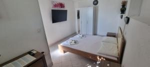 a small bedroom with a white bed and a mirror at Hrstich Apartments in Drasnice