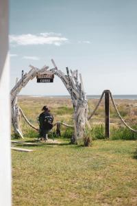 a person sitting in a chair under an arch in a field at Rezident Corbu in Corbu