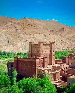 a village in the desert with a mountain in the background at Kasbah des roses in Aït Saïd