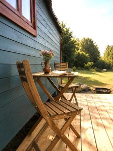 a wooden table and chair on a porch with a table and flowers at Stativa Przygorze201 Sowie Góry in Przygórze +7 photos