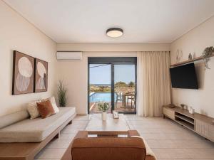 a living room with a couch and a tv at Corali Villas - Seaview, Private Pools, 450 to Beach in Kolymvari