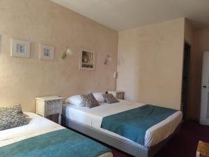 a hotel room with two beds in a room at Hôtel Saint Jean in Orange