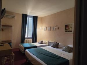 a hotel room with two beds and a window at Hôtel Saint Jean in Orange