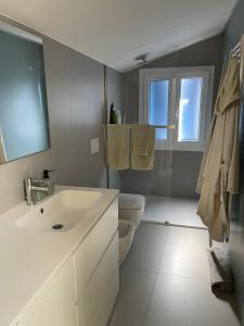 a white bathroom with a sink and a toilet at Casa Ficcanaso in Caorle +19 photos