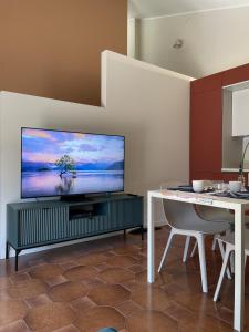a living room with a flat screen tv and a table at Casa Ficcanaso in Caorle