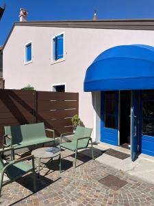 a building with a blue awning and two chairs at Casa Ficcanaso in Caorle