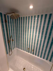 a bath tub in a bathroom with green and white stripes at The Red Lion in Blewbury