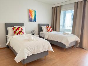 ein Schlafzimmer mit zwei Betten und einer Couch in der Unterkunft Mon Koti in Turku