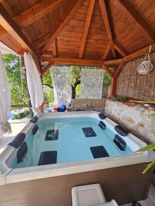 a hot tub in a pavillion with a wooden roof at Villa Lora in Tučepi