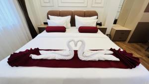 two swansuitsrendered to look like birds sitting on a bed at Aabuu Babuu Resort & Banquet in Kurseong +1 photo