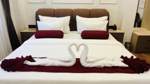 two swans towels are made to look like swans on a bed at Aabuu Babuu Resort & Banquet in Kurseong