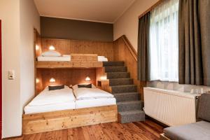 a bedroom with a bunk bed and a staircase at JUFA Hotel Maria Lankowitz am See in Maria Lankowitz