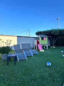 a group of chairs in a yard with a playground at Studio neuf avec acces piscine in Valergues +8 photos