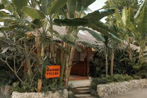 a sign in front of a bunch of plants at Manao Villas - Luxury Boutique Resort in General Luna