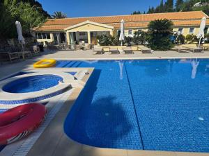a large swimming pool with a yellow frisbee next to it at Corfu valley view in Paleokastritsa