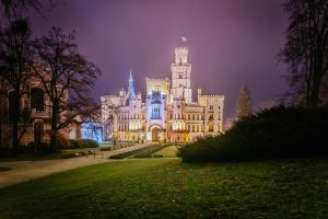 a large castle building at night with its lights on at Hotel Štekl in Hluboká nad Vltavou