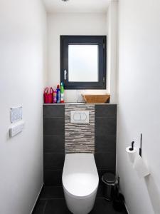 a bathroom with a white toilet and a window at Beautiful, modern room in Saint-Paul-de-Varax