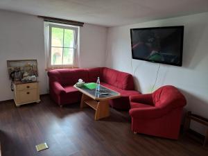 a living room with a red couch and a table at Unseburger Brauhaus - FW7 in Unseburg