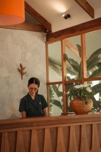 a woman standing behind a counter with a window at Manao Villas - Luxury Boutique Resort in General Luna