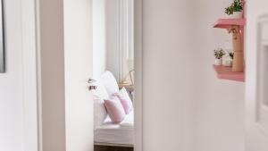 a bedroom with a white bed with pink pillows at STACEY Alster in Hamburg