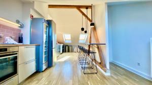 a kitchen with wooden floors and blue cabinets and stools at STACEY Alster in Hamburg