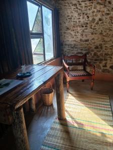 a wooden table and bench in a room with a window at Winterdodgers Backpackers and Campsite in Sodwana Bay