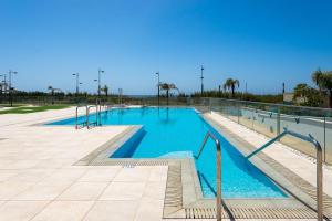 a large swimming pool with blue water and stairs at Luxurious Two Bed in Torrox